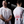 Load image into Gallery viewer, A person wearing a white unisex muscle fit t-shirt with a unique Pitstop-inspired graphic, standing in front of a mirror.