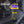 A clear shaker bottle with a purple and yellow lid and base, standing on a gym bench. The bottle has the brand name 'DNA SPORTS' printed in yellow on the front.